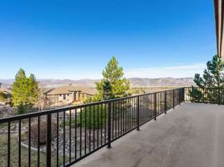 Enjoy breathtaking views from this stunning property! This home features a spacious balcony with a sleek black railing, perfect for relaxing and taking in the scenery.