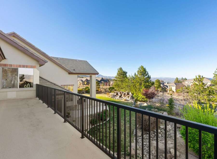 Enjoy breathtaking views from this stunning property! This home features a spacious balcony overlooking a beautifully landscaped yard and the surrounding neighborhood.