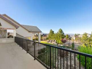 Enjoy breathtaking views from this stunning property! This home features a spacious balcony overlooking a beautifully landscaped yard and the surrounding neighborhood.