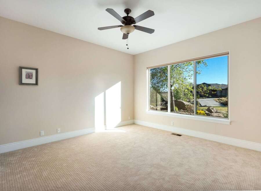 This spacious room offers a serene atmosphere with its neutral color palette and abundant natural light.