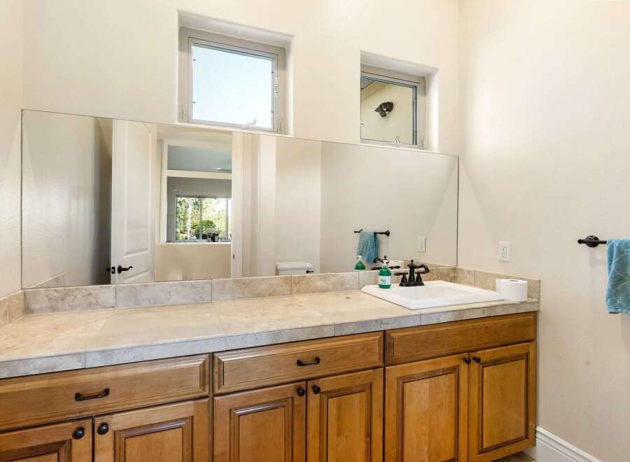 This stunning bathroom features a large mirror, perfect for getting ready in the morning.