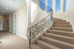 This stunning property features a grand staircase with intricate wrought iron railings, adding a touch of elegance to the home.
