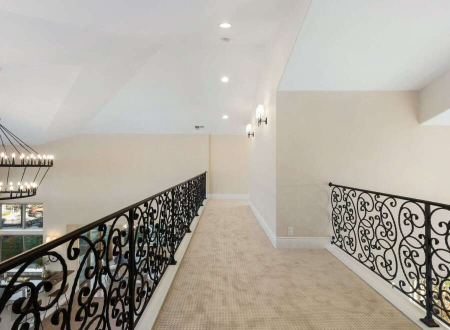 This stunning property features a grand hallway with elegant wrought iron railings.