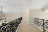 This stunning property features a grand hallway with elegant wrought iron railings.
