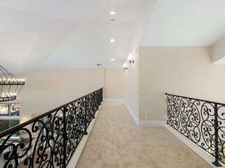 This stunning property features a grand hallway with elegant wrought iron railings.