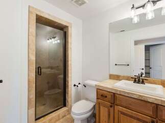 Step into a beautifully designed bathroom featuring a spacious walk-in shower with a glass door and elegant tile surround.