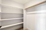 Step into this spacious walk-in closet, offering ample storage with its multiple shelves.