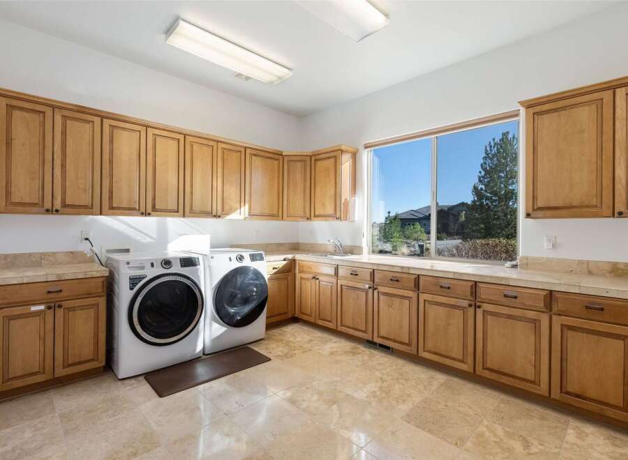 This stunning laundry room boasts ample storage with custom cabinetry and a bright, airy feel.