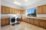 This stunning laundry room boasts ample storage with custom cabinetry and a bright, airy feel.
