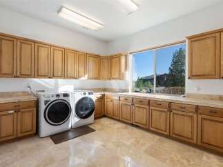 This stunning laundry room boasts ample storage with custom cabinetry and a bright, airy feel.