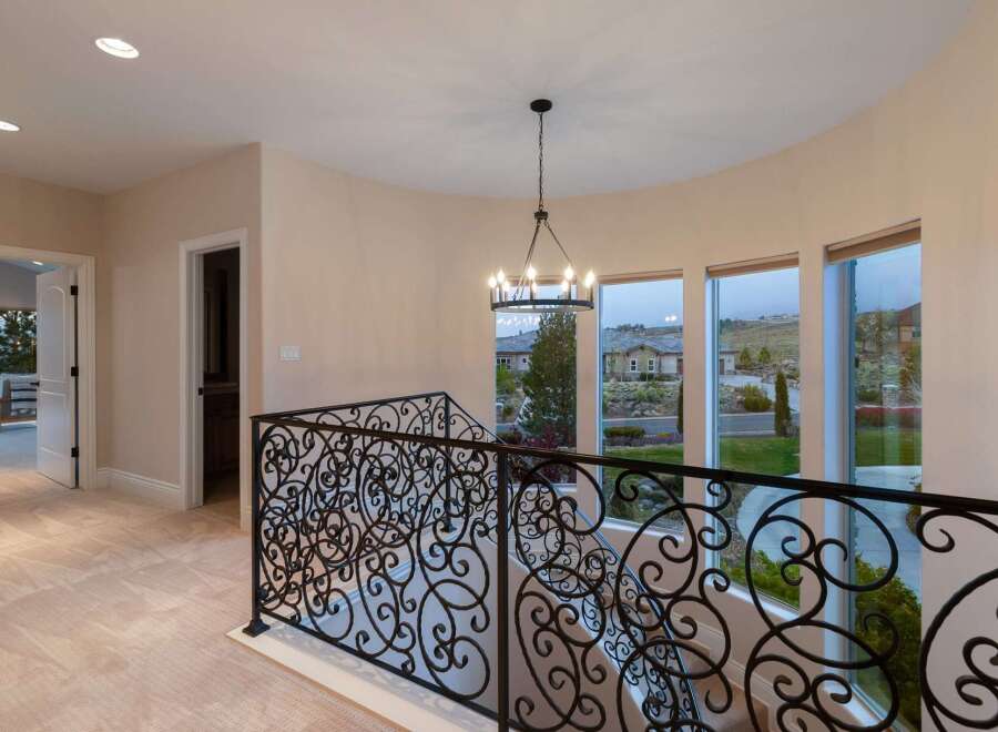 Step into luxury with this stunning property featuring an elegant staircase and wrought iron railing.