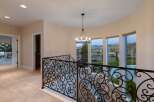 Step into luxury with this stunning property featuring an elegant staircase and wrought iron railing.