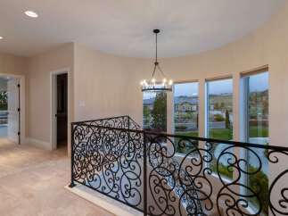 Step into luxury with this stunning property featuring an elegant staircase and wrought iron railing.