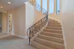 This stunning property boasts a grand staircase with intricate wrought iron railings, adding a touch of elegance to the home.