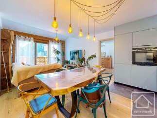 Experience the charm of this stunning property, featuring a beautifully designed dining area with a unique wooden table and stylish chairs.