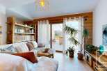 Experience the charm of this cozy living space, featuring a rustic wooden bookshelf and a comfortable sofa.