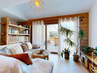 Experience the charm of this cozy living space, featuring a rustic wooden bookshelf and a comfortable sofa.