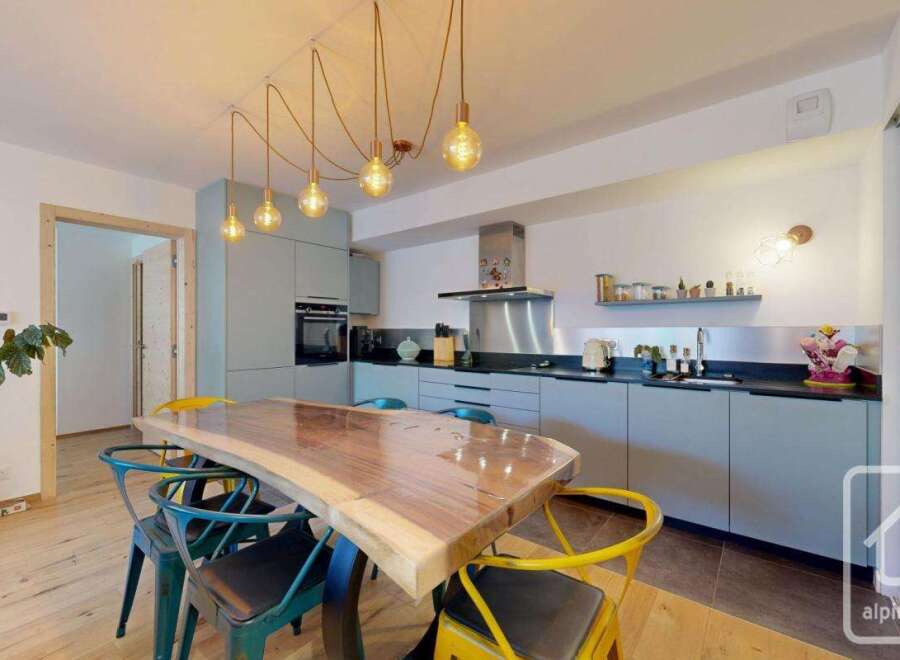 Discover this stunning kitchen with a unique live-edge wooden dining table, perfect for entertaining.