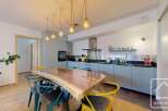 Discover this stunning kitchen with a unique live-edge wooden dining table, perfect for entertaining.
