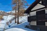 Discover a charming mountain chalet nestled in a snowy landscape, perfect for a winter getaway.