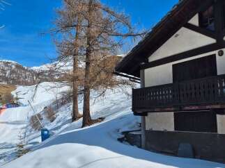 Discover a charming mountain chalet nestled in a snowy landscape, perfect for a winter getaway.