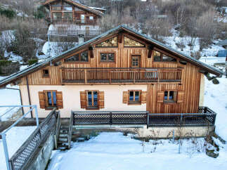 Discover a charming chalet nestled in a snowy landscape, perfect for a cozy retreat.