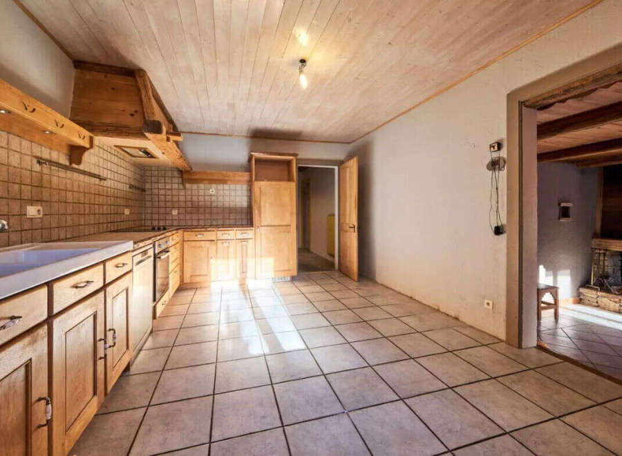 Step into this charming kitchen, featuring warm wooden cabinetry and a classic tile backsplash.
