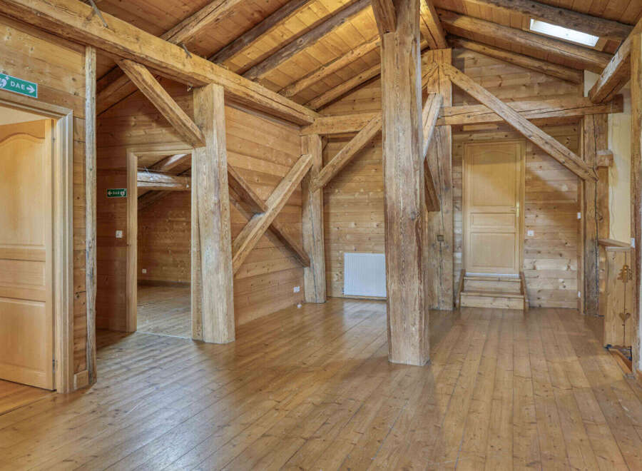This stunning property boasts a unique architectural design with exposed wooden beams and a warm, inviting atmosphere.