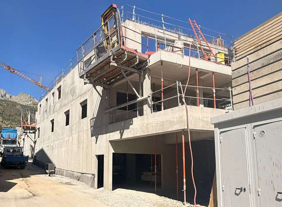 This image showcases a multi-story concrete building under construction, featuring robust structural elements and scaffolding.