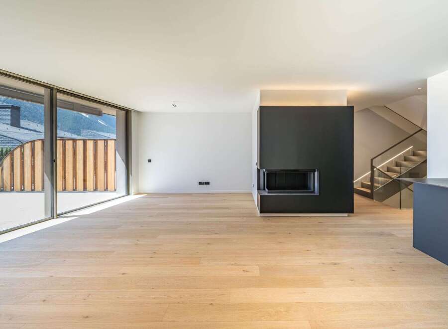 This modern living space boasts a sleek design with a cozy fireplace and stunning natural light.