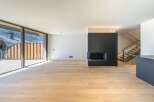 This modern living space boasts a sleek design with a cozy fireplace and stunning natural light.