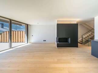 This modern living space boasts a sleek design with a cozy fireplace and stunning natural light.