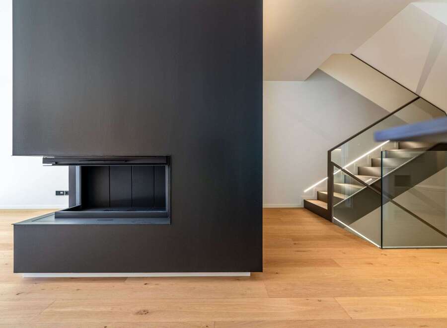 This modern home boasts a sleek, minimalist design with a stunning black fireplace as its focal point.
