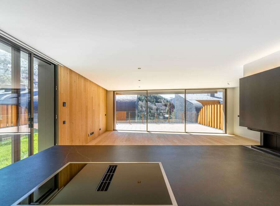 Experience luxury living in this stunning property, featuring a modern kitchen with sleek countertops and a built-in cooktop.