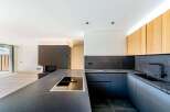 This modern kitchen boasts sleek, dark countertops and cabinetry, creating a sophisticated and stylish space.
