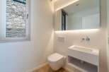 This modern bathroom features a sleek, minimalist design with a wall-mounted toilet and sink.