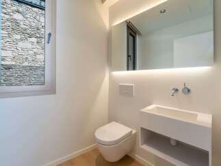 This modern bathroom features a sleek, minimalist design with a wall-mounted toilet and sink.