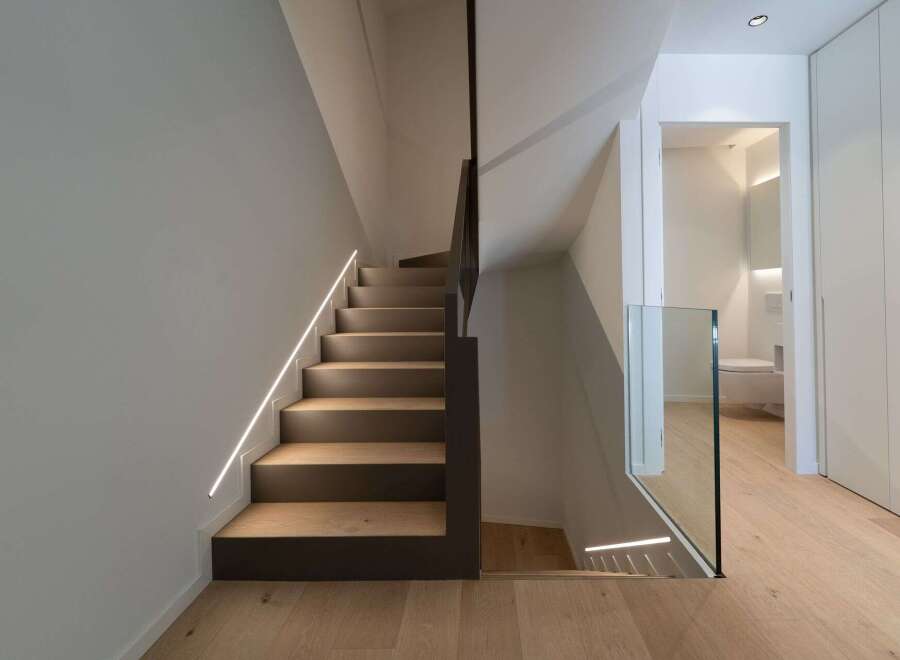 This stunning property features a modern staircase design with integrated lighting, creating a sleek and inviting atmosphere.
