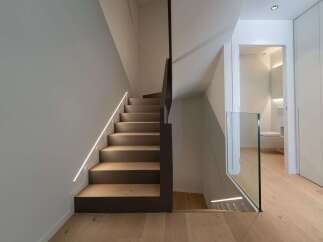 This stunning property features a modern staircase design with integrated lighting, creating a sleek and inviting atmosphere.