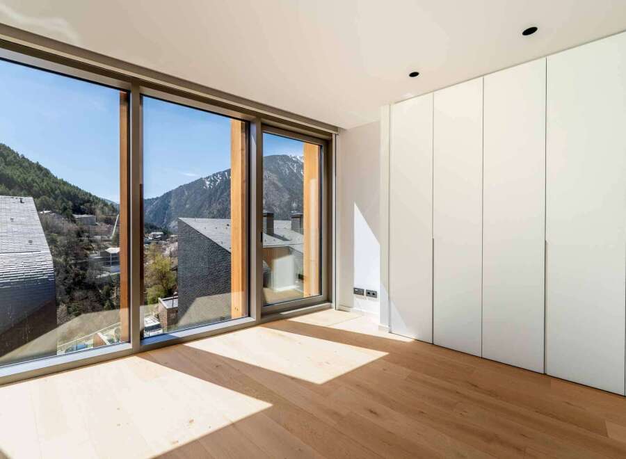 Experience the breathtaking views from this modern property, featuring expansive windows that frame the stunning mountain landscape.