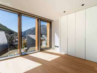 Experience the breathtaking views from this modern property, featuring expansive windows that frame the stunning mountain landscape.