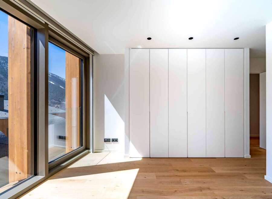 Experience the epitome of modern living in this stunning property, boasting expansive windows that frame breathtaking mountain views.