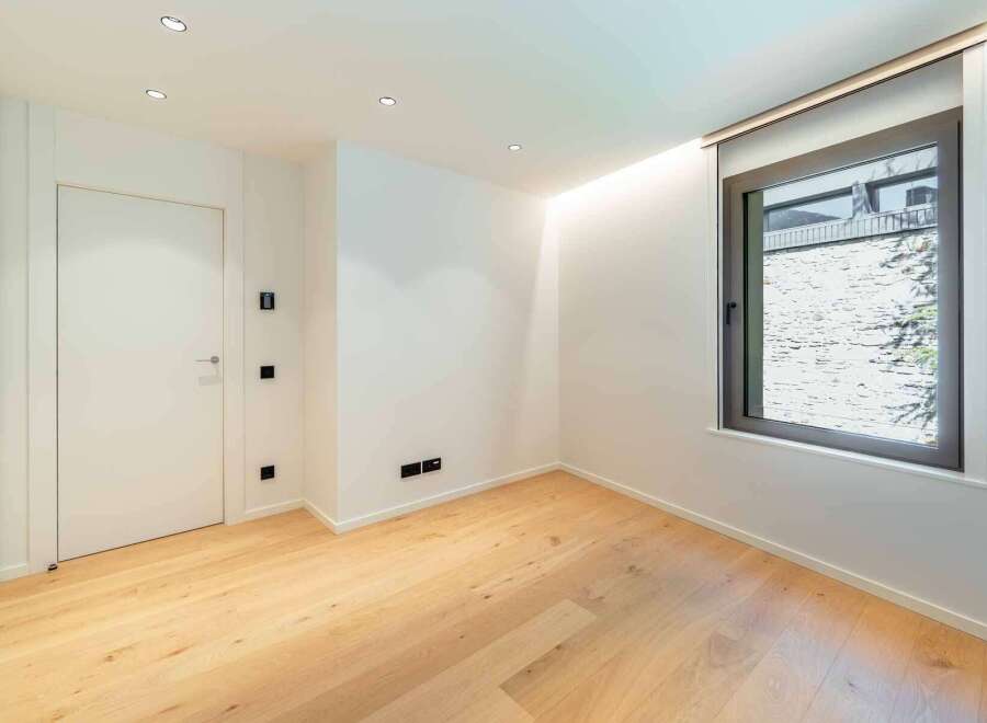 This modern room features beautiful hardwood floors and crisp white walls, creating a bright and inviting atmosphere.