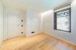 This modern room features beautiful hardwood floors and crisp white walls, creating a bright and inviting atmosphere.