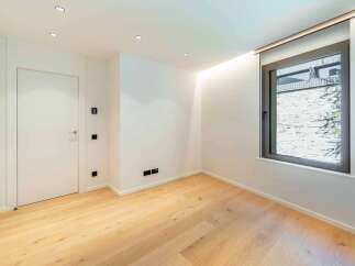 This modern room features beautiful hardwood floors and crisp white walls, creating a bright and inviting atmosphere.