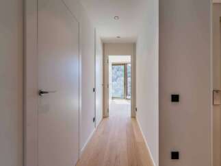 This stunning hallway showcases a modern and minimalist design, perfect for any contemporary home.