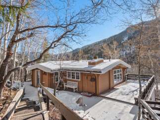 Nestled in a serene winter landscape, this charming cabin offers a cozy retreat.