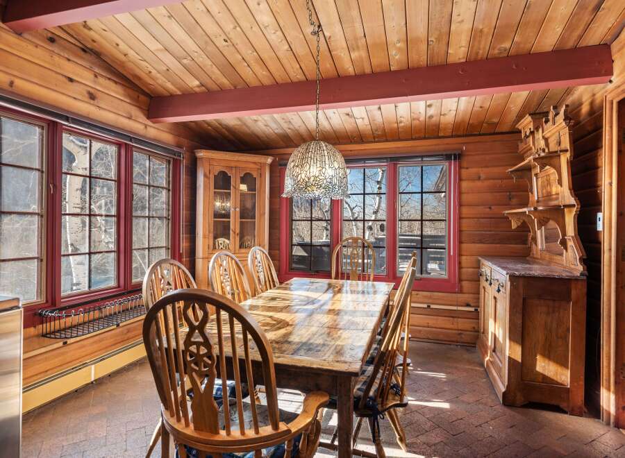 Step into this charming dining room, featuring a rustic wooden table and chairs, perfect for family gatherings.