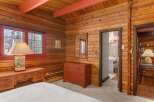 Step into rustic charm with this inviting bedroom, featuring warm wood paneling and a cozy ambiance.