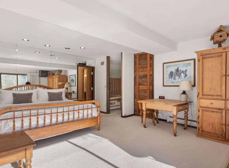 This spacious bedroom offers a serene retreat with its light-filled ambiance and elegant design.